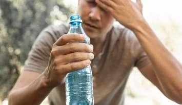 Man drinking water during heat wave (Image from kieferpix / iStock / Getty Images Plus via Getty Images)