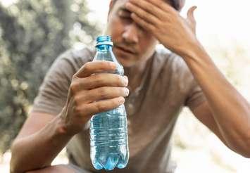 Man drinking water during heat wave (Image from kieferpix / iStock / Getty Images Plus via Getty Images)