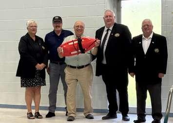 Sarnia-Lambton MPP Bob Bailey holds a lifeguard rescue buoy at the Moore Sports Complex when awarding $1 million for the facility to council members. July, 2025. Image courtesy of the Mooretown Sports Complex Facebook page.